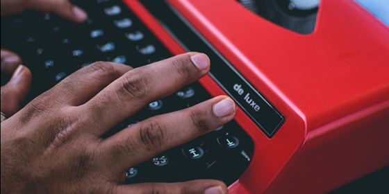image of a person typing on a typewriter