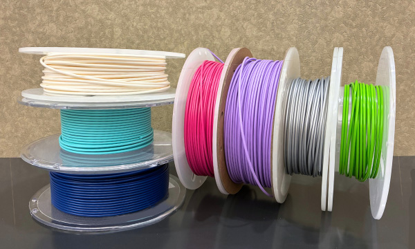 Spools of 3D printing filaments in various colors
