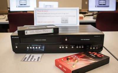 VHS to digital converter with VHS tapes next to it.