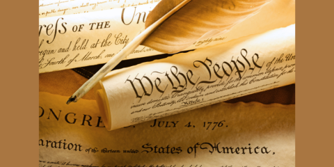 A close-up photograph of a scroll of the Declaration of Independence featuring the text, 