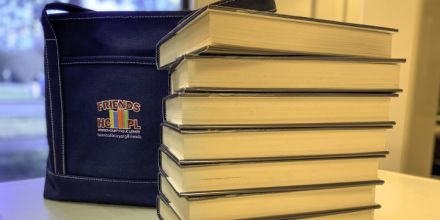 image: a book bag behind a stack of books
