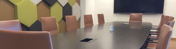 Image of a conference room with table, chairs, and television screen
